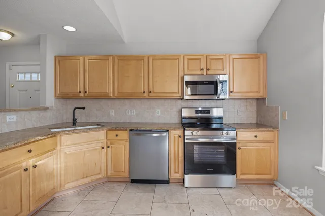 a kitchen with cabinets stainless steel appliances and a sink