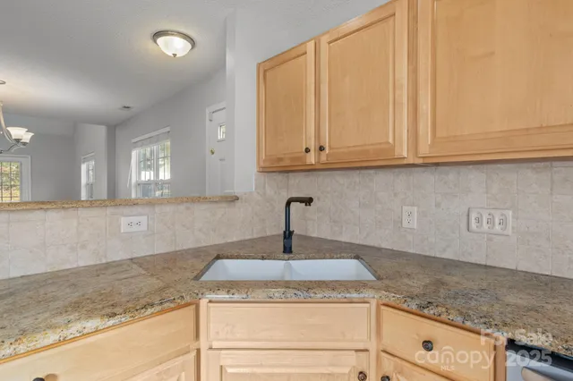 a kitchen with granite countertop a sink and white cabinets