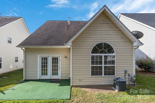 a view of a house with a yard and a large tree