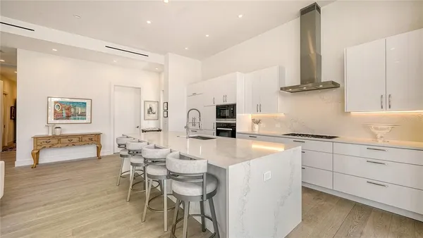 a kitchen with a white stove top oven and chairs