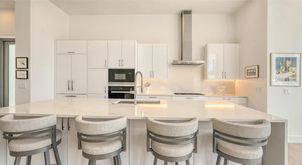 a kitchen with stainless steel appliances a large window a table and chairs