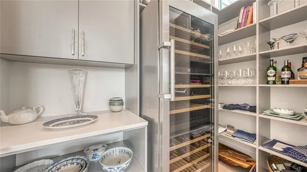 a large white kitchen with granite countertop a large counter top and sink