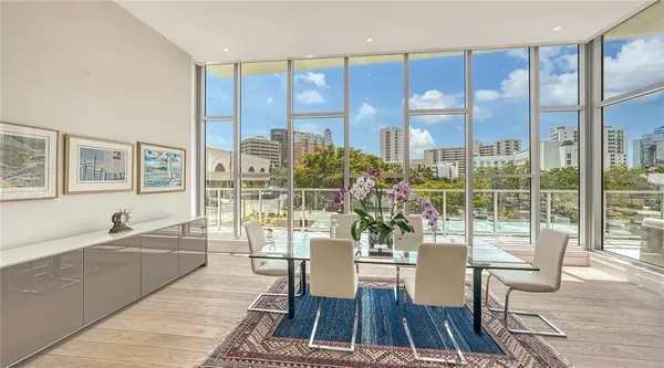 a view of a dining room with furniture a chandelier and wooden floor