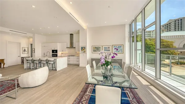 a living room with furniture dining table and a large window