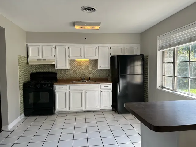 a kitchen with a refrigerator stove and cabinets