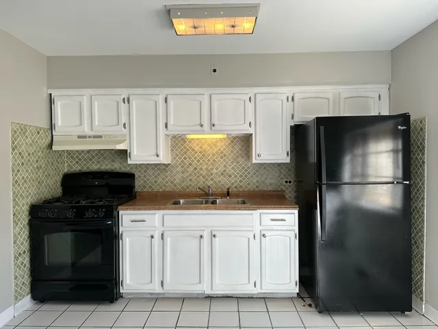 a kitchen with white cabinets and stainless steel appliances