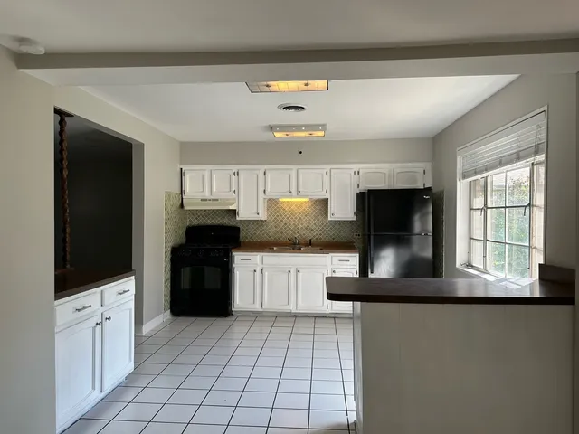 a kitchen with granite countertop a refrigerator and a stove top oven