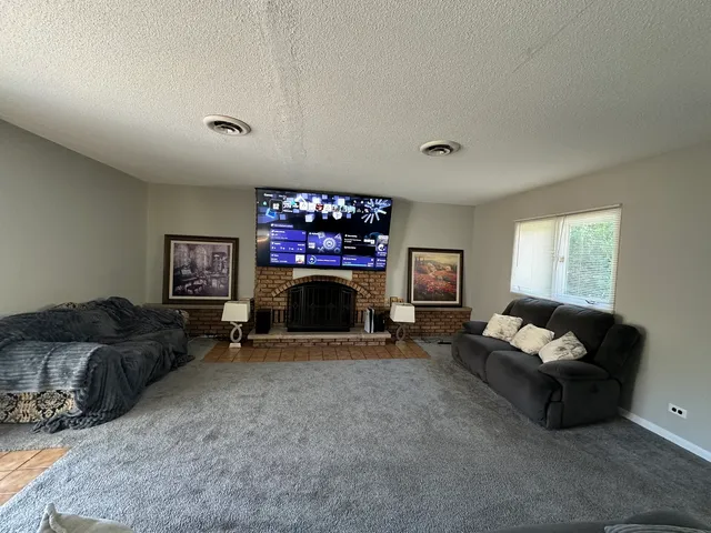 a living room with furniture a fireplace and a flat screen tv