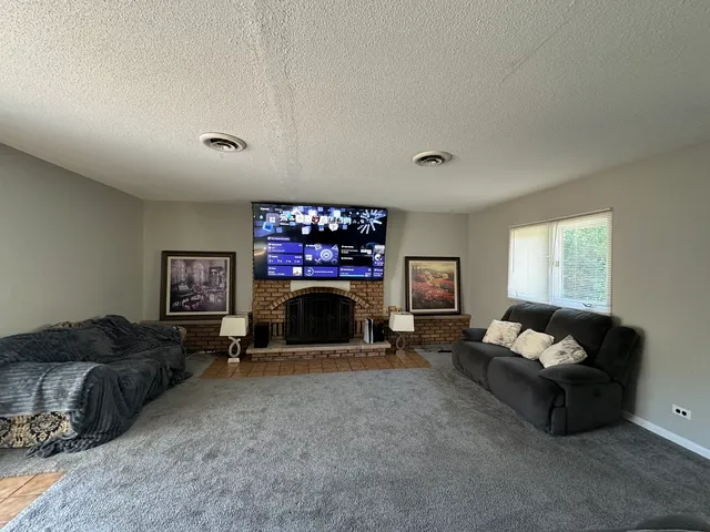 a living room with furniture a fireplace and a flat screen tv