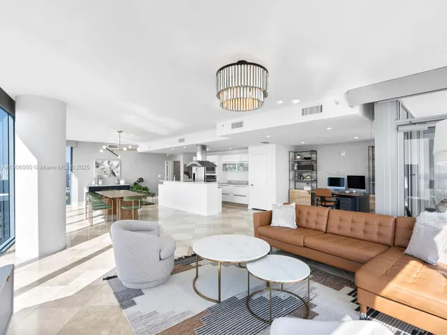 a living room with furniture a rug and a chandelier