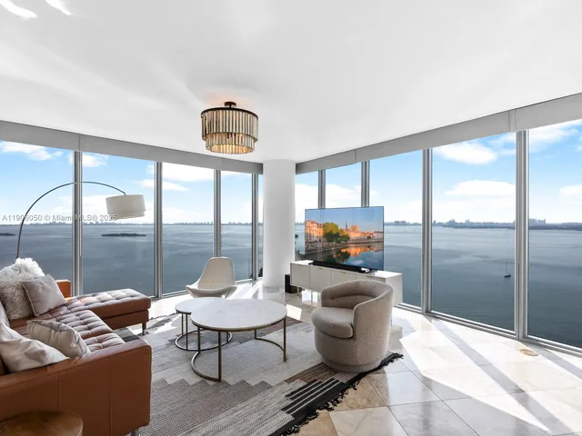 a living room with furniture and a floor to ceiling window