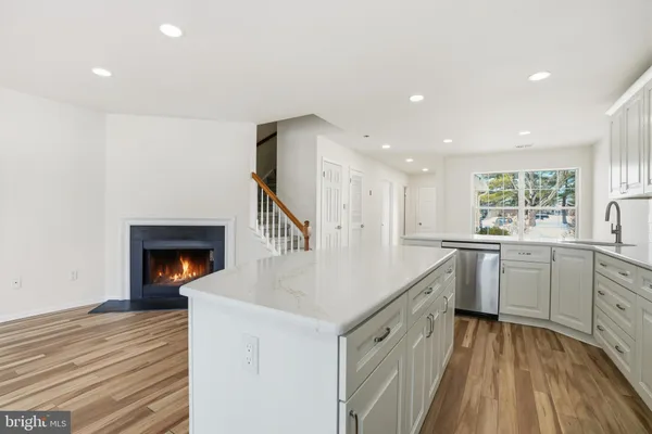 a kitchen with white cabinets and sink