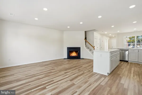 a view of a kitchen with wooden floor and a fireplace