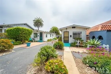 a front view of a house with a yard and potted plants