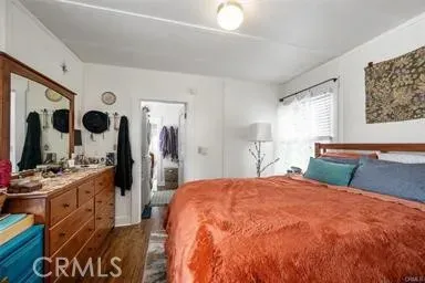 a large bedroom with a bed and a flat tv screen on dresser