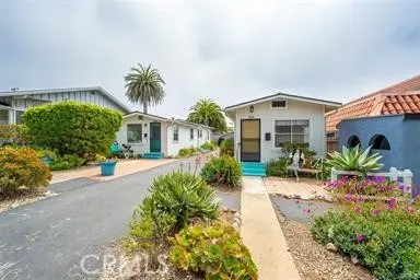 a front view of a house with a yard and potted plants
