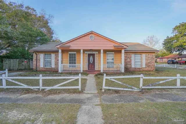 a view of house with a big yard and a large tree