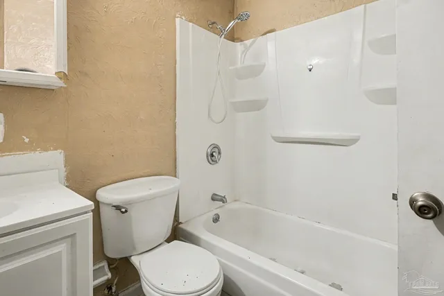 a white toilet sitting next to a bath tub