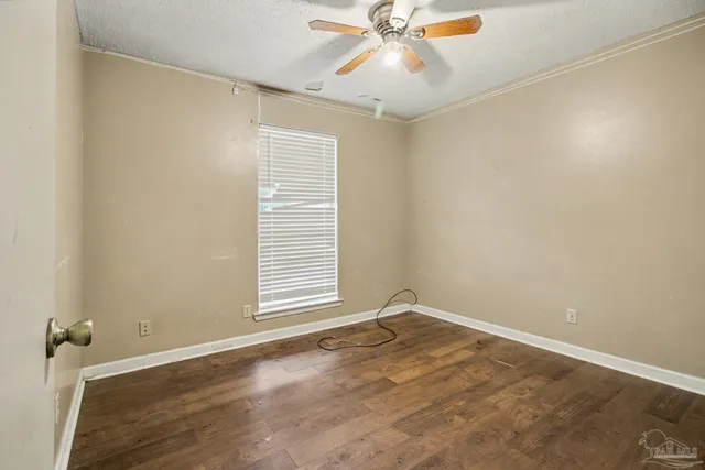 an empty room with a window and a fan
