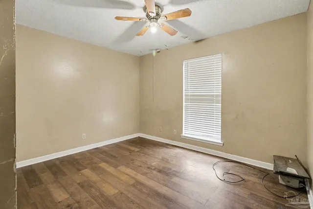 an empty room with windows and fan
