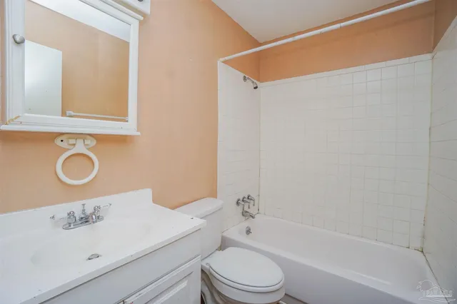 a bathroom with a bathtub sink vanity mirror and toilet