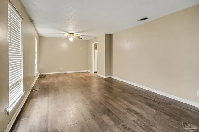 wooden floor in an empty room with a window