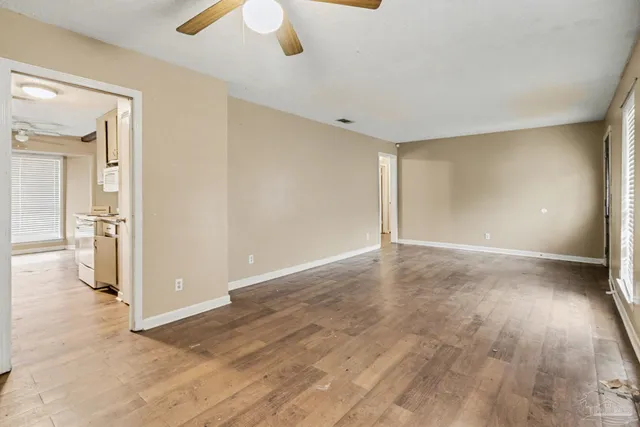 a view of empty room with wooden floor