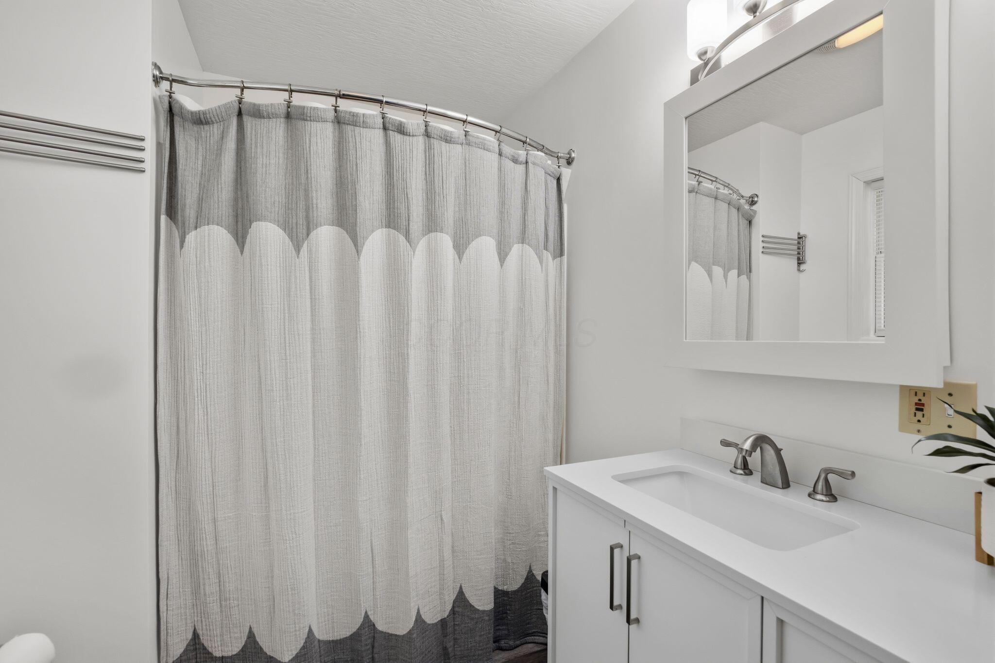 10446 Rich Hollow Road Southwest Lancaster, OH 43130 - Photo 48 of 83 White vanity with integrated sink, brushed nickel faucet, and framed mirror with overhead light fixture