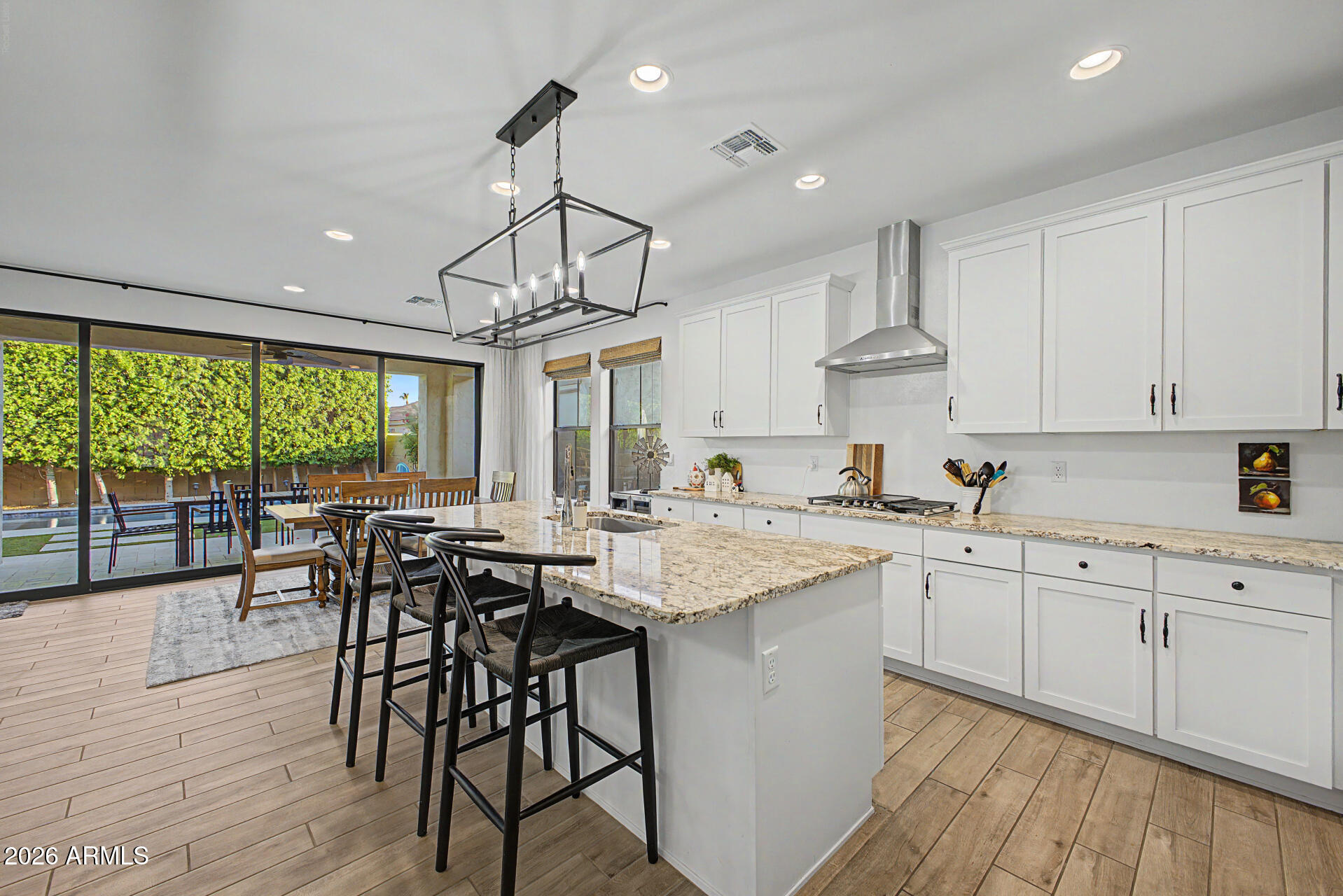 819 West Deer Creek Road Phoenix, AZ 85048 - Photo 25 of 76 a kitchen with stainless steel appliances granite countertop a stove a refrigerator a white table and chairs with wooden floor