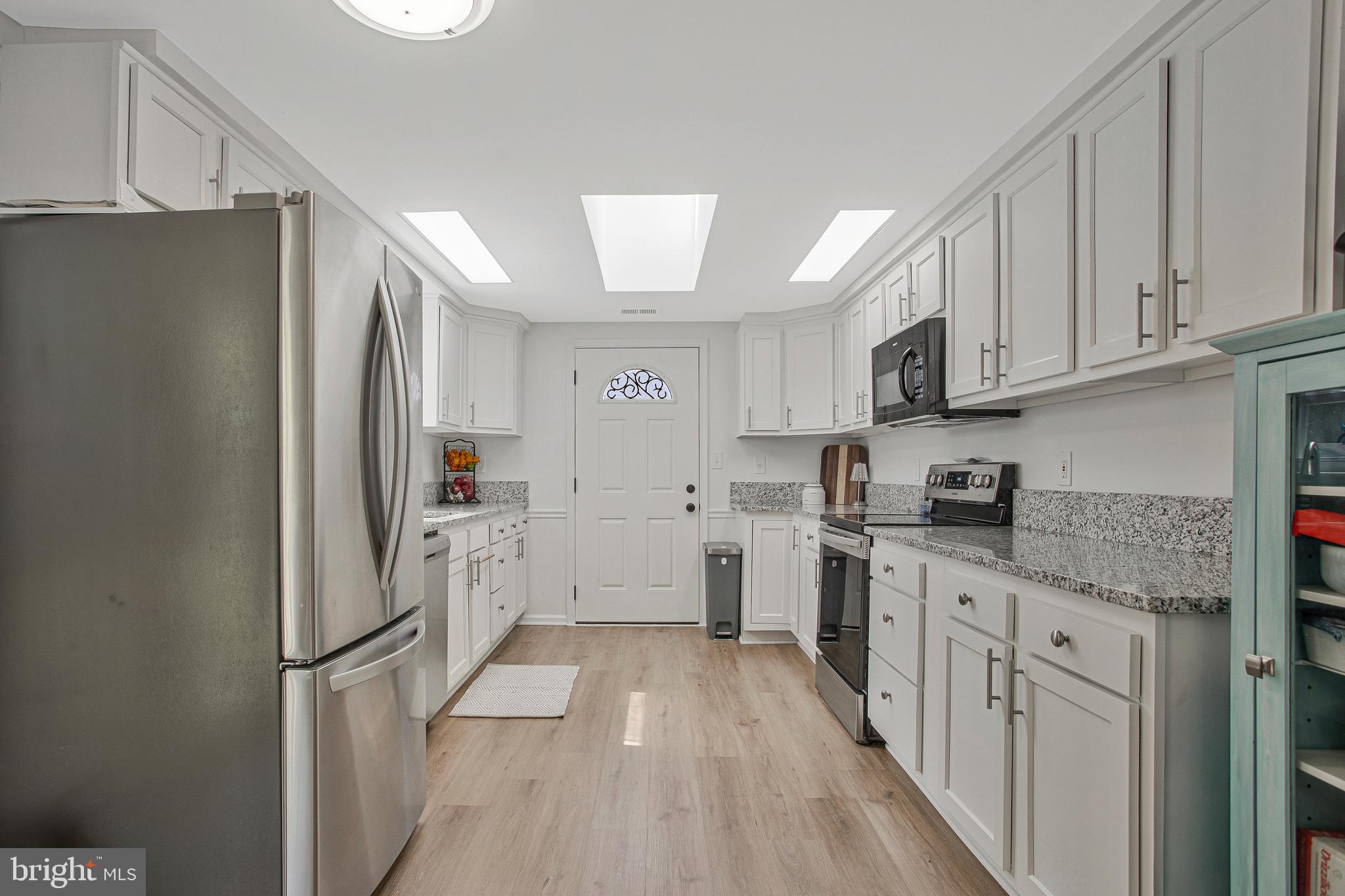 114 River Road Edgewater, MD 21037 - Photo 13 of 30 a kitchen with white cabinets and white appliances