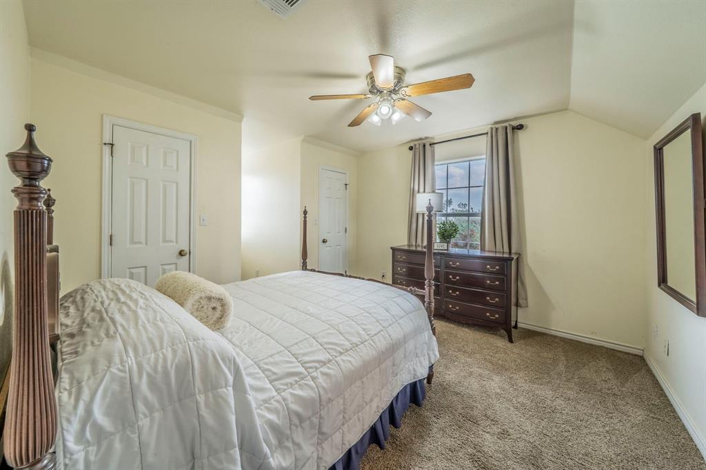 1992 Bledsoe Road Gunter, TX 75058 - Photo 17 of 40 a bedroom with a bed and a chandelier