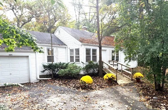 a view of a house with a yard covered in snow