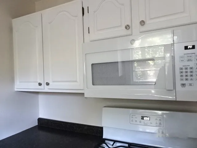 a view of a kitchen with wooden floor and cabinets