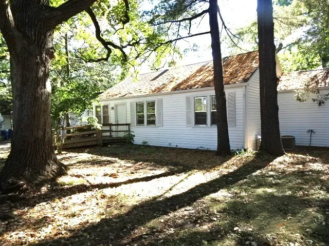 a balcony with wooden floor and trees in the back