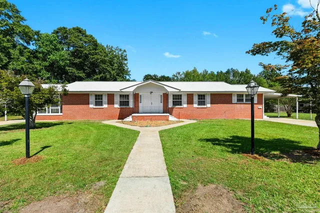a view of a house with a backyard and a patio