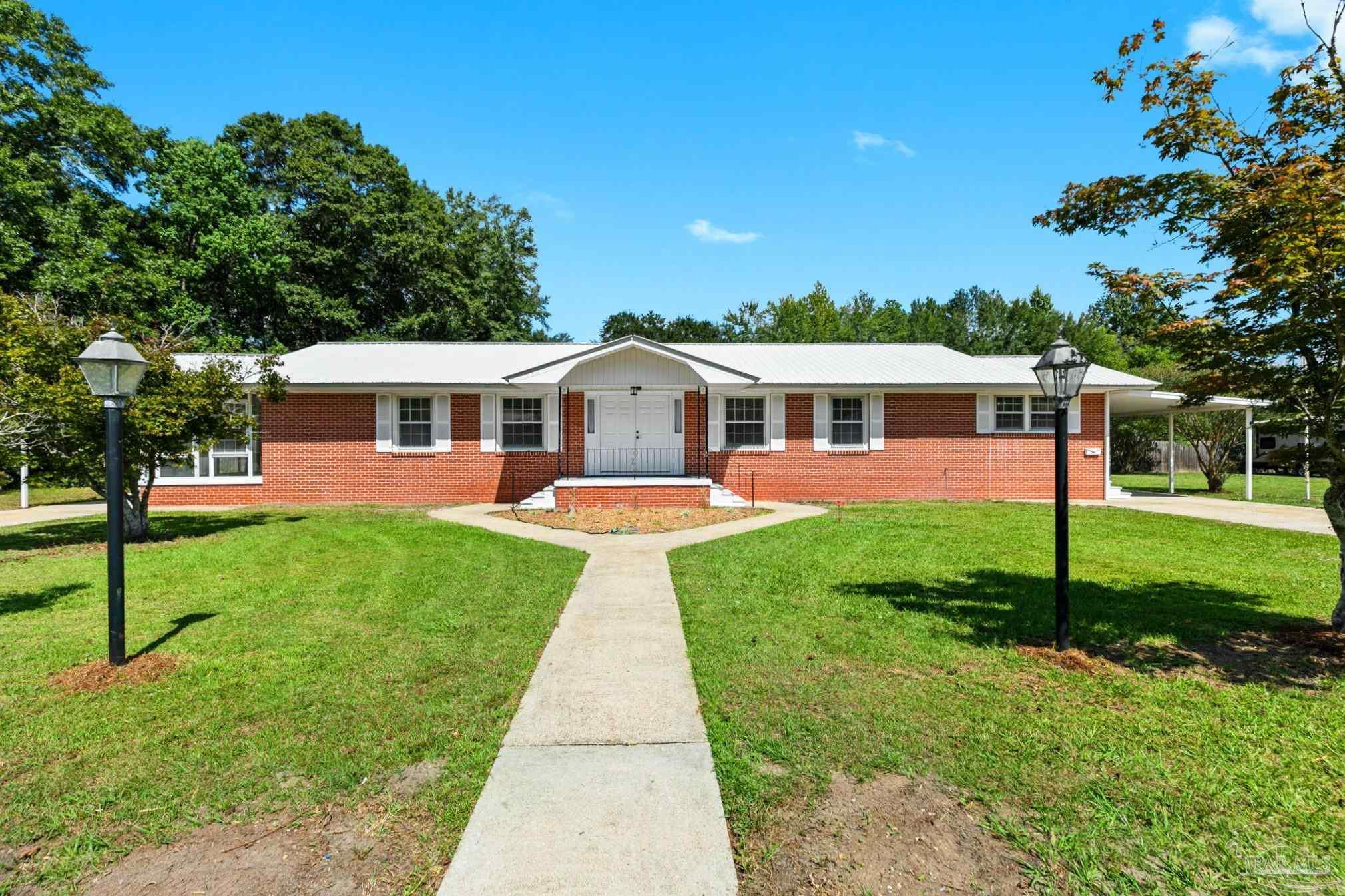 a view of a house with a backyard and a patio