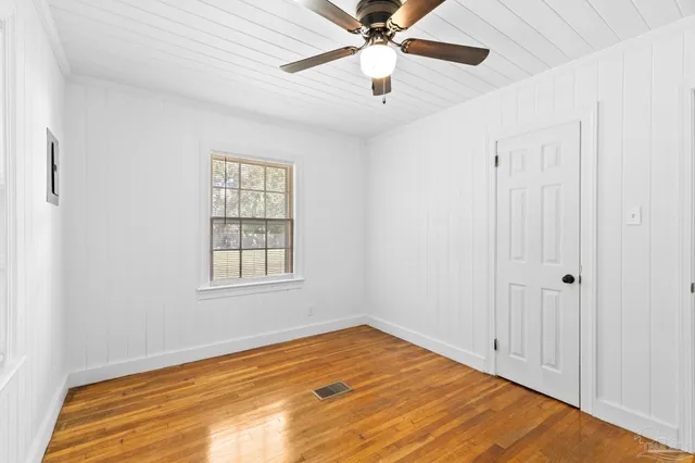 a view of empty room with wooden floor