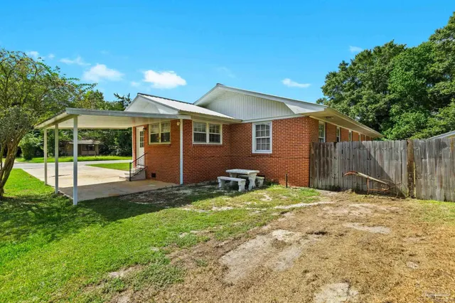a view of a house with a yard and sitting area