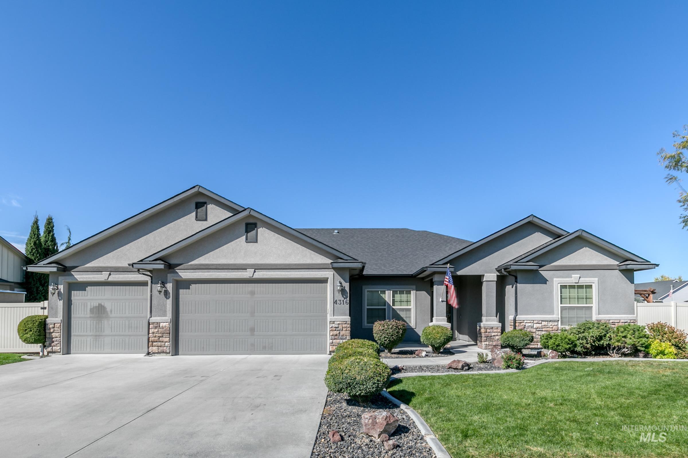 4316 Middlesboro Way Caldwell, ID 83607 - Photo 1 of 33 Stucco exterior with stone accents, dark shingles, an attached three-car garage, concrete driveway, and established landscaping