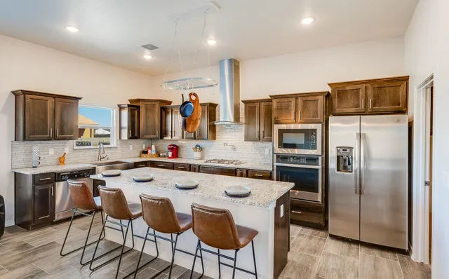 a large kitchen with stainless steel appliances granite countertop a stove and a sink