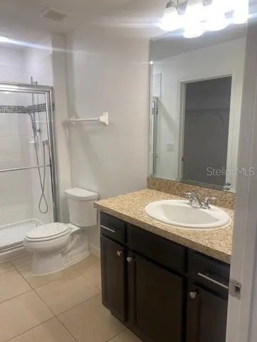 a bathroom with a granite countertop sink toilet and shower