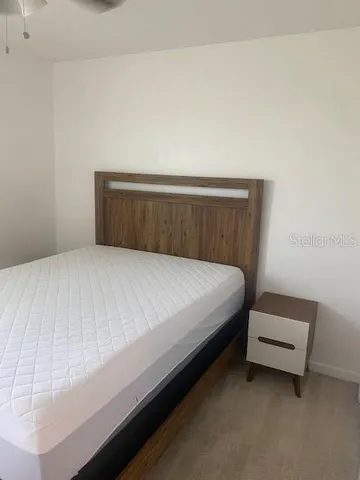 a bed sitting in a bedroom with a white wall