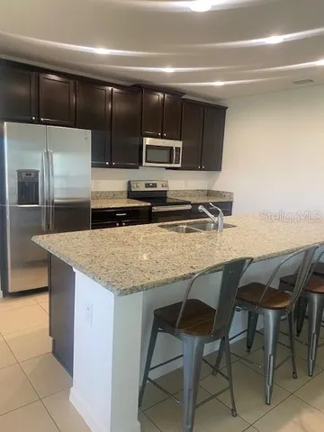 a kitchen with kitchen island a counter top space cabinets and stainless steel appliances