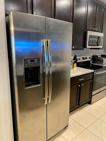 a kitchen with stainless steel appliances granite countertop a refrigerator and a stove