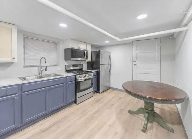 a kitchen with a sink cabinets stainless steel appliances and a window