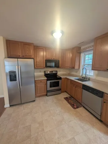 a kitchen with granite countertop a refrigerator and a sink