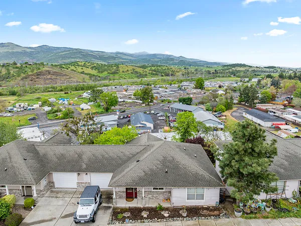 an aerial view of residential houses with outdoor space and street view