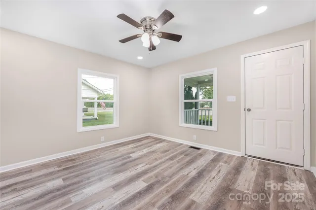 an empty room with window and a ceiling fan