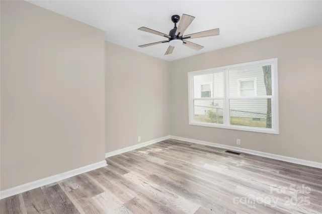 a view of a big room with wooden floor and windows in a room
