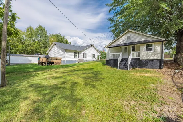 a view of a house with a big yard and large trees